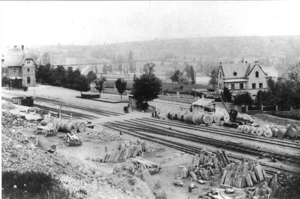 Kottenheim um 1900. Links im Bild ist der Bahnhof zu erkennen. Entlang der Gleise warten zahlreiche Mühlsteine auf ihren Abtransport.