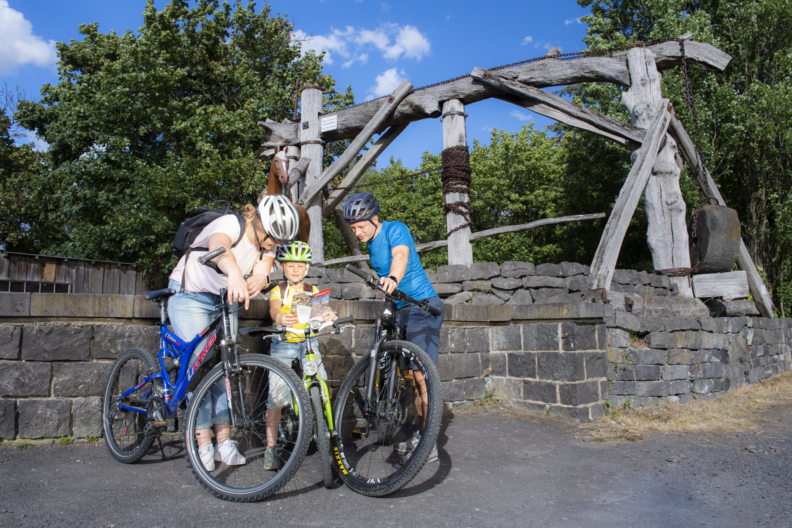 Familie mit Fahrrädern vor einem Göpelwerk.
